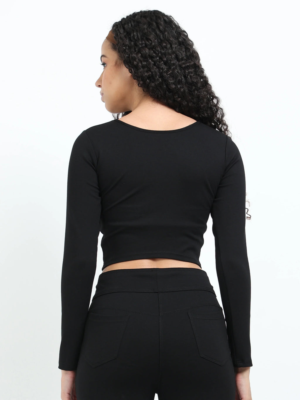 Close-up of fabric texture and stitching on black long sleeve crop top hem