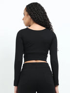 Close-up of fabric texture and stitching on black long sleeve crop top hem