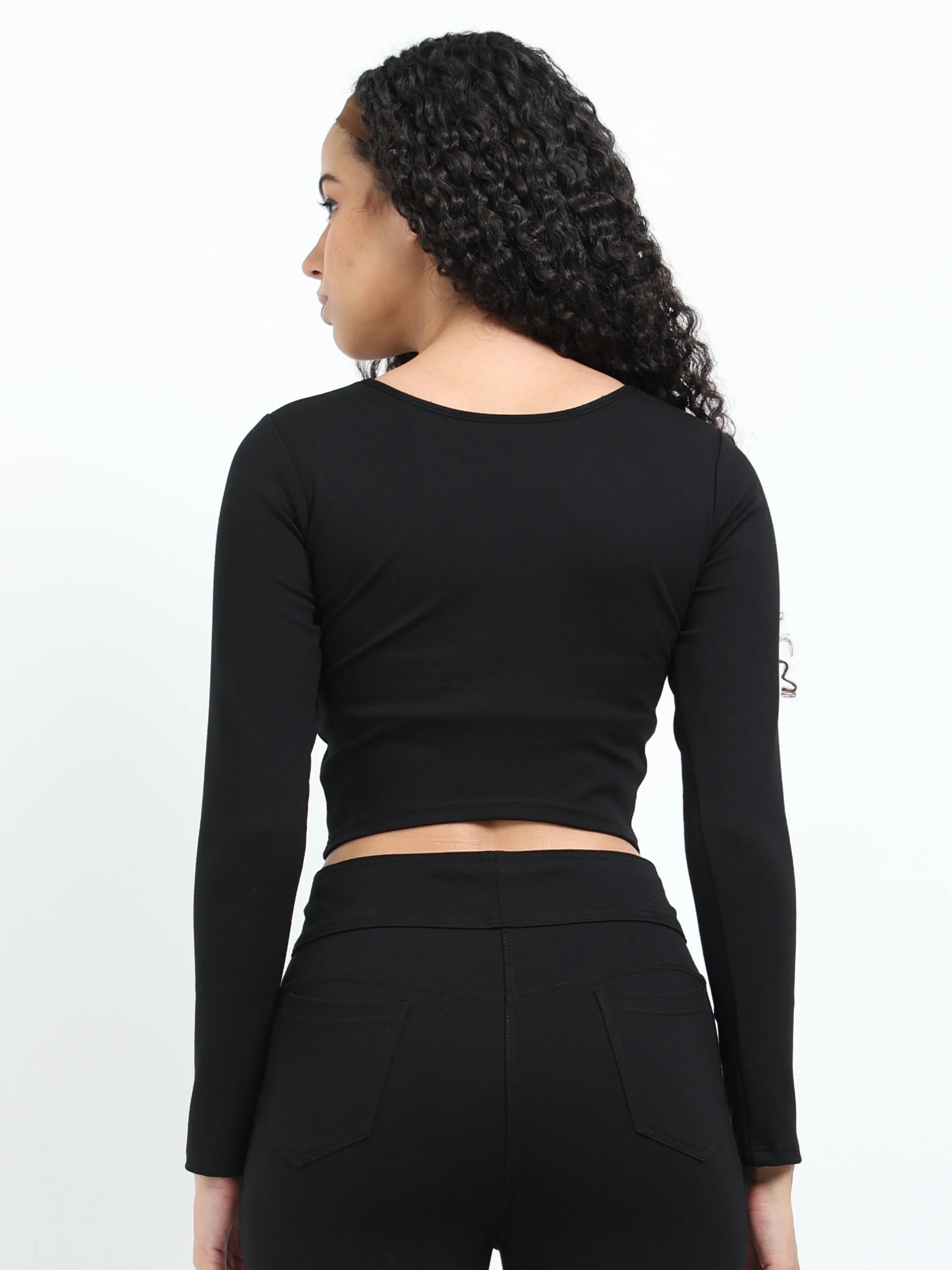 Close-up of fabric texture and stitching on black long sleeve crop top hem