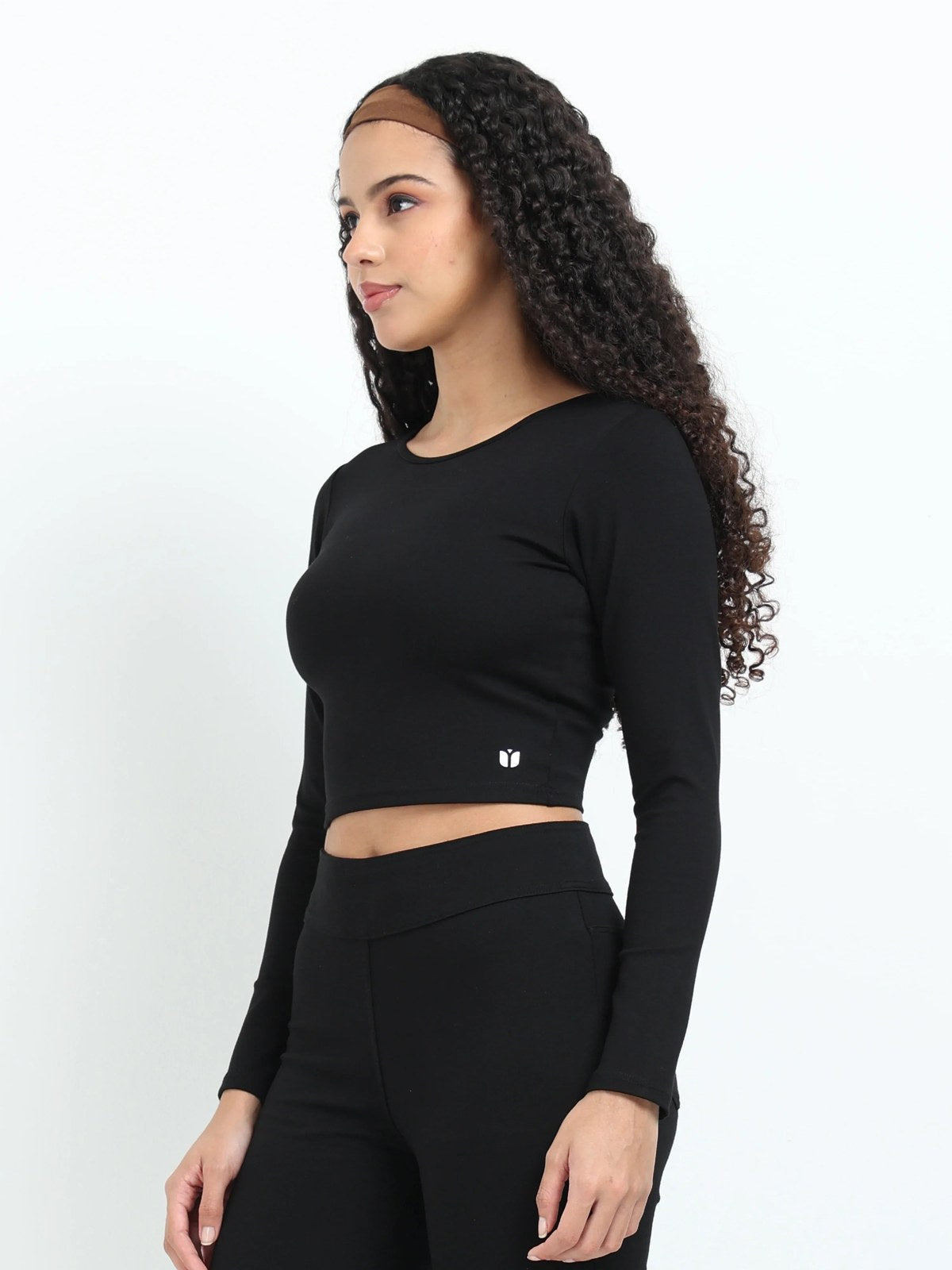 Black long sleeve crop top lifestyle shot, full body with matching leggings, sneakers and water bottle