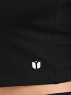 Close-up of Yellowcrop logo emblem on black long sleeve crop top