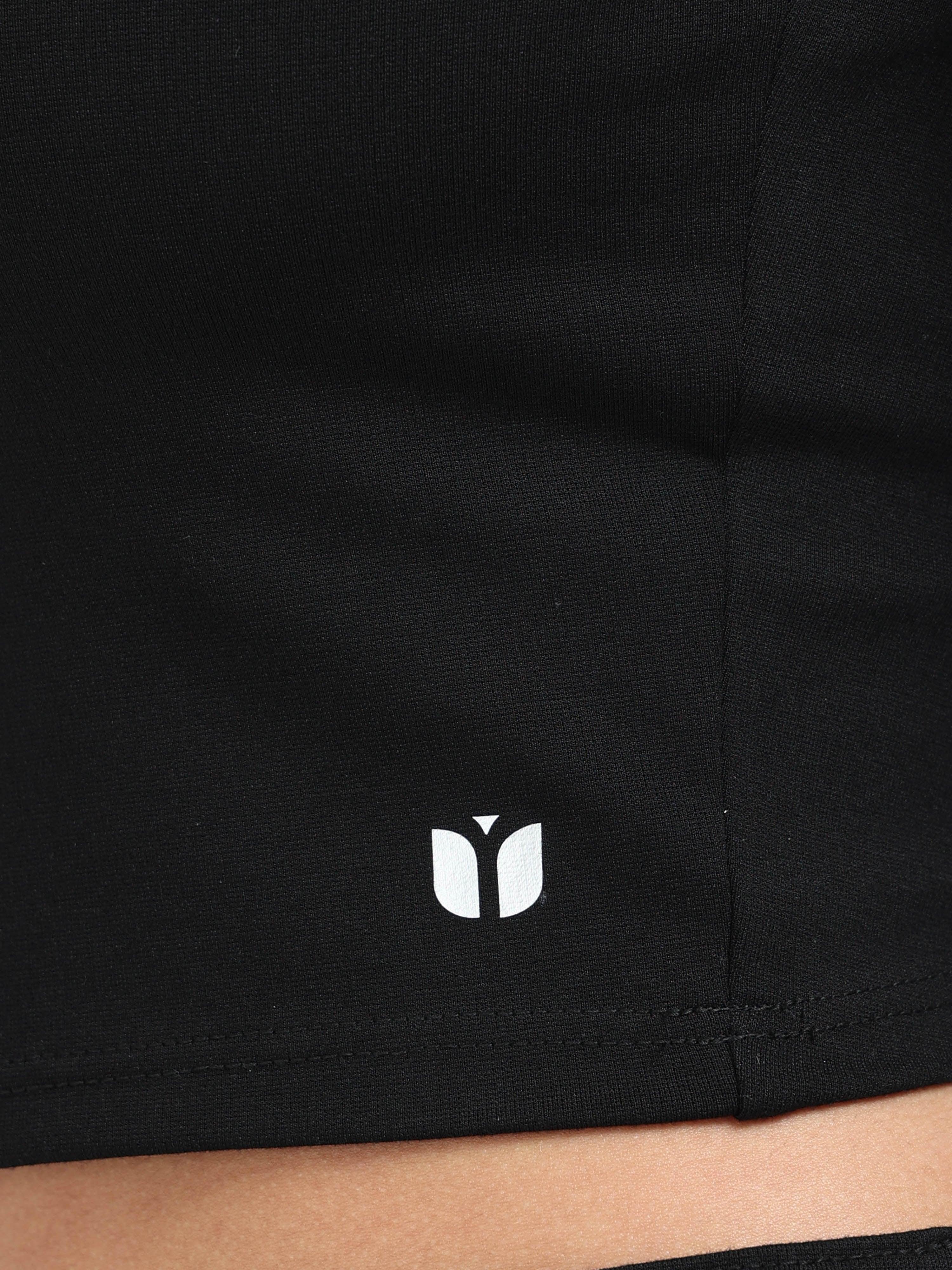 Close-up of Yellowcrop logo emblem on black long sleeve crop top