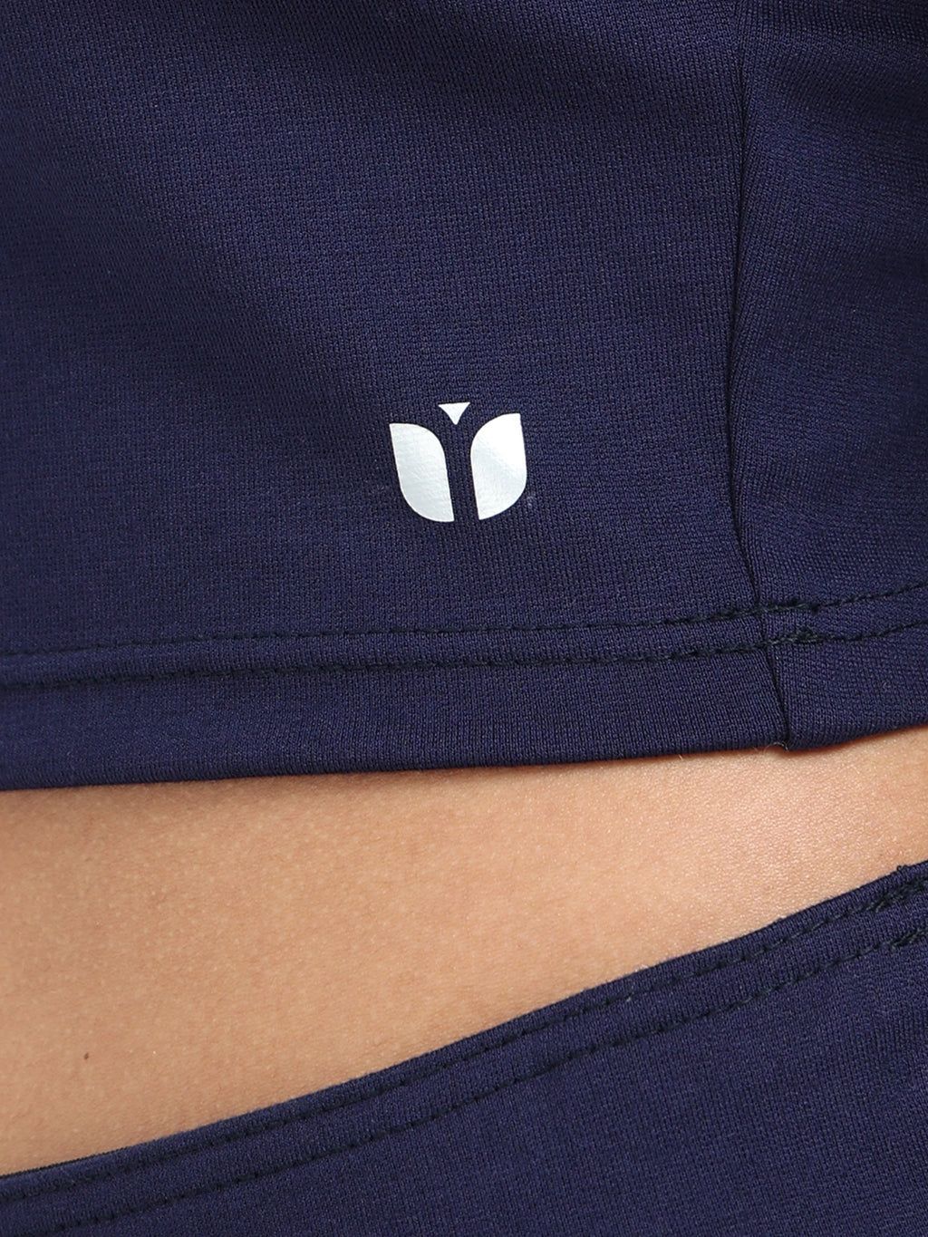 Close-up of fabric texture and stitching on navy long sleeve crop top hem