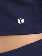 Close-up of fabric texture and stitching on navy long sleeve crop top hem