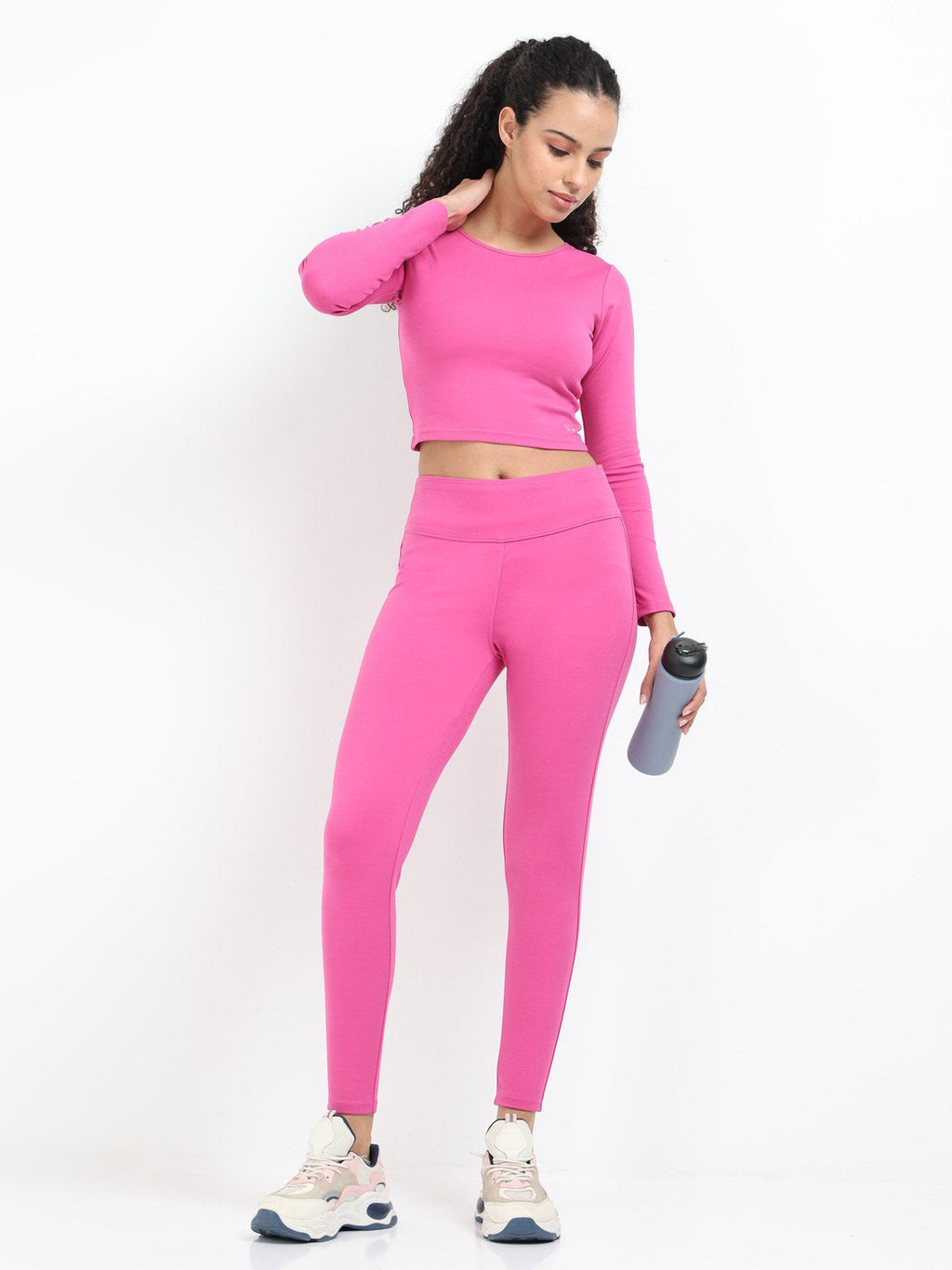 Pink long sleeve crop top lifestyle shot, full body with matching leggings, sneakers and water bottle