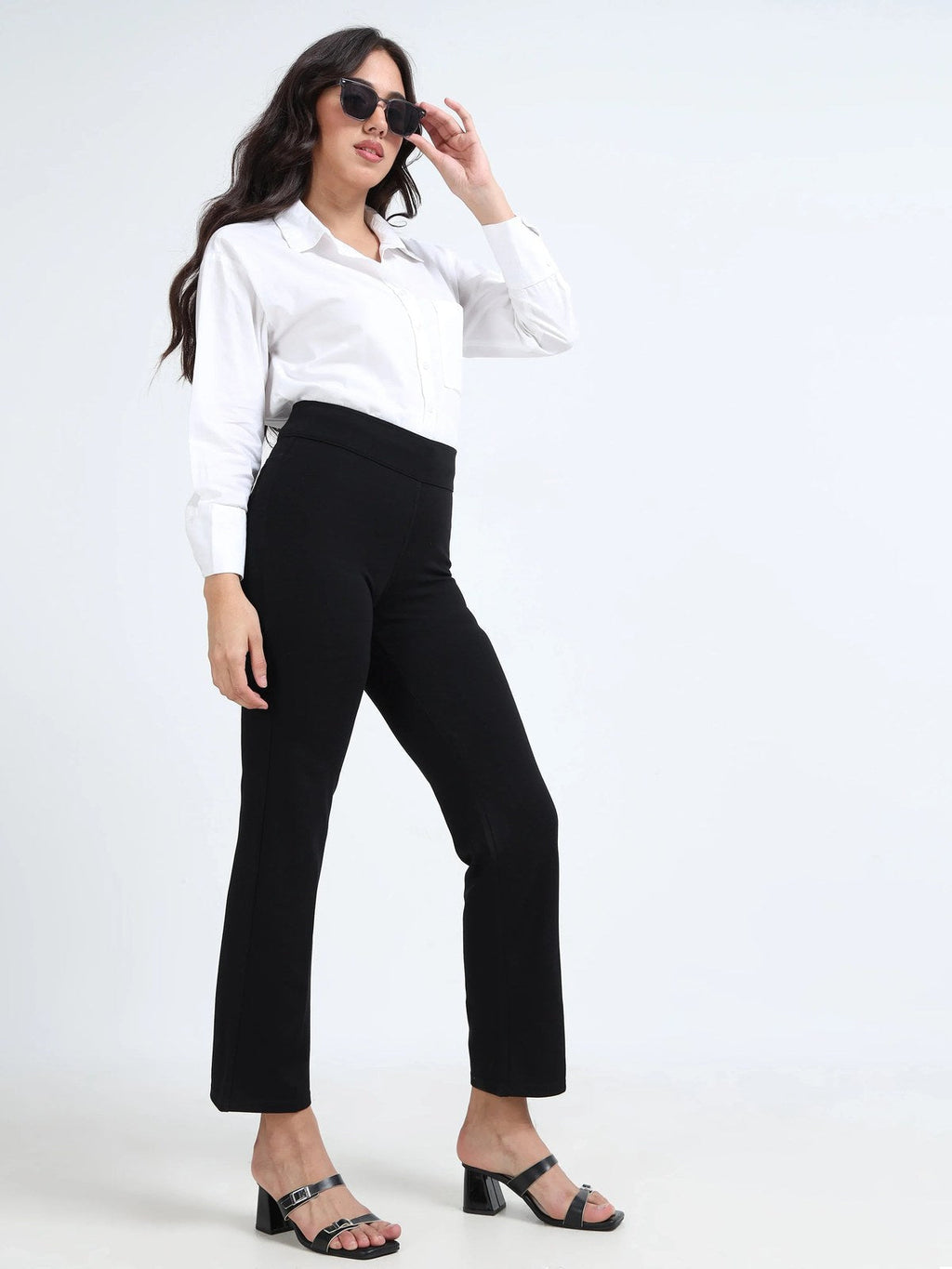 Black straight pants alternate lifestyle pose, model holding sunglasses with block heels